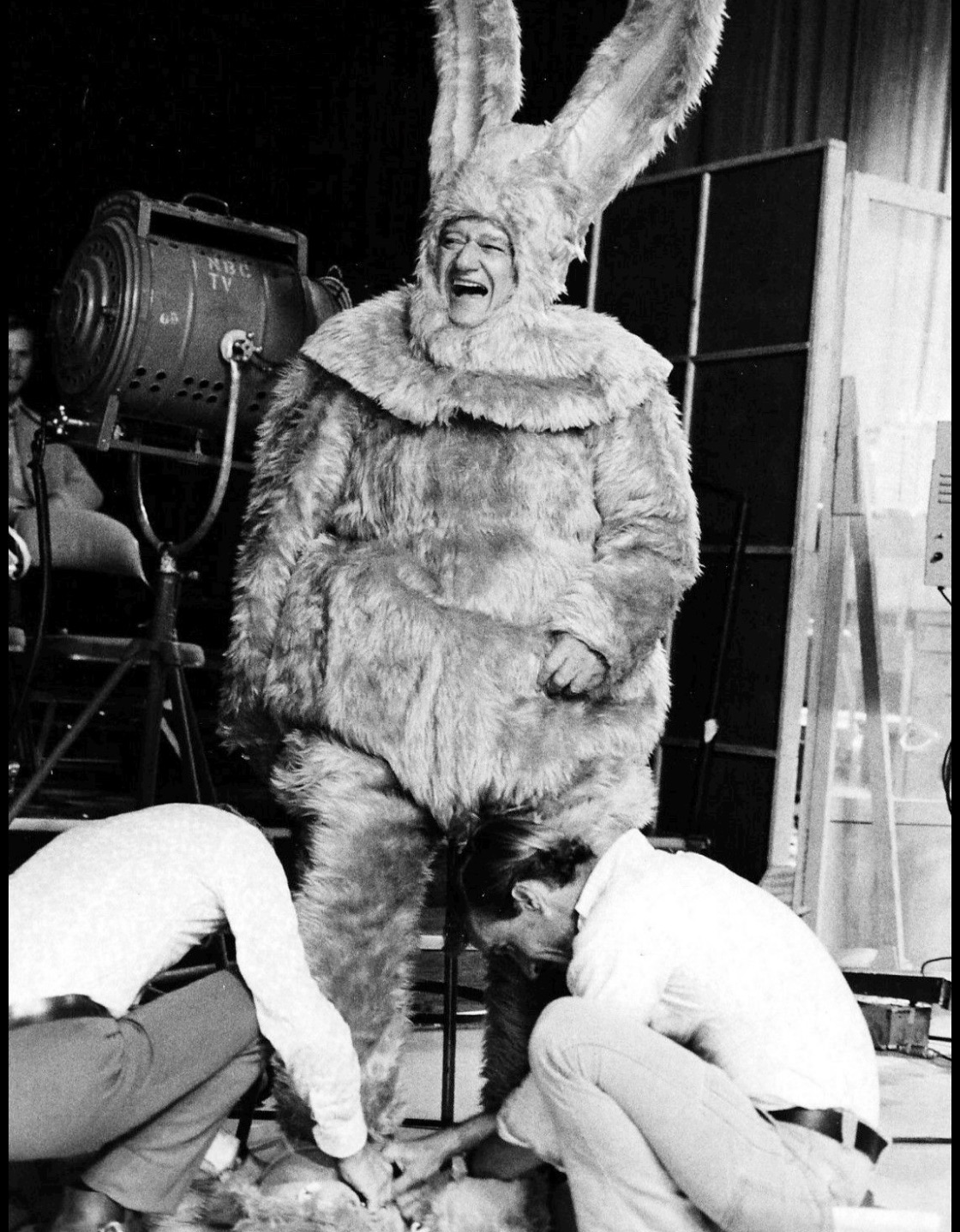 John Wayne being fitted for a giant bunny costume 